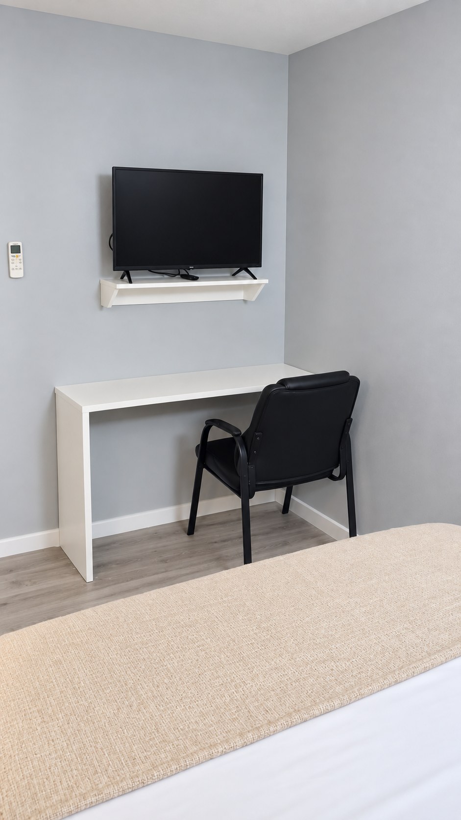 Work desk, chair and wall-mounted TV in a Point Bay Hotel queen room